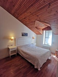 a bedroom with a bed and a wooden ceiling at Eco Hotel Mundaka in Mundaka