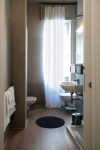 baño con lavabo y aseo y ventana en Dante 12, en Vigevano