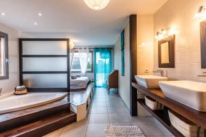 - Baño con 2 lavabos, bañera y cama en Villa tout confort - Piscine - Montagnes - Lac - Parking, en Armoy