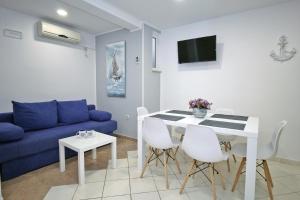 a living room with a blue couch and a table at Apartments Miovic in Molunat