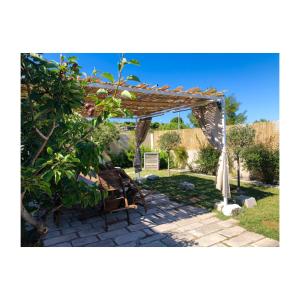 a wooden pergola with a bench and a table at Bio&B Acquaviva in Otranto