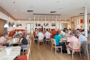 a group of people sitting at tables in a restaurant at AllgäuWeite in Sulzberg