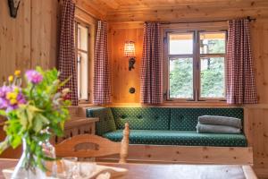 a living room with a green couch and windows at Chalet Berghaus Manuaf in Tschagguns