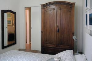 a bedroom with a wooden cabinet next to a bed at Dante 12 in Vigevano