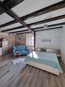 a bedroom with a bed and a blue couch at Heritage Apartments Trumbić in Split