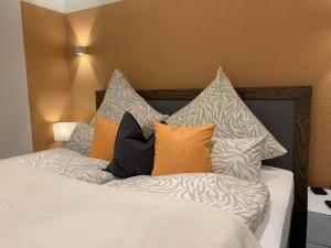 - un lit avec des oreillers orange et blancs dans l'établissement Harzfewo Köhnke 4, à Goslar