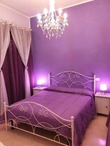 ローマにあるB&B La Casa di Gabryの紫色のベッドルーム(ベッド1台、シャンデリア付)