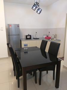 eine Küche mit einem Tisch mit Stühlen und einem Kühlschrank in der Unterkunft Aliff Avenue Studio in Johor Bahru