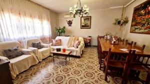 ein Wohnzimmer mit einem Sofa und einem Tisch sowie ein Esszimmer in der Unterkunft La Casa de Mera a 18km de Puy du Fou in Cabañas de la Sagra