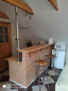 a kitchen with a brick counter and two chairs at Agroturystyka Patynówka in Kletno