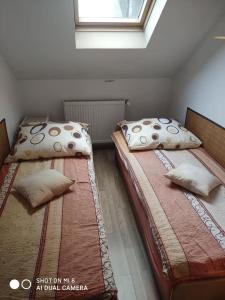 duas camas sentadas uma ao lado da outra num quarto em Agroturystyka Patynówka em Kletno