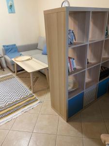a living room with a table and a book shelf at Tiny Bijou Sea View studio - Santa Marina - Sozopol in Sozopol