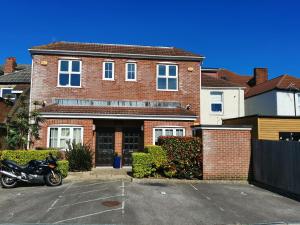 una motocicleta estacionada frente a una casa de ladrillo en Poseidon Friends en Bournemouth