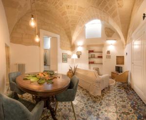 een grote woonkamer met een tafel en stoelen bij FORLEO Historic Apartments - TREB Collection in Lecce
