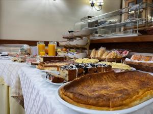 a table with many different types of cakes and pastries at Costa Trasmiera in Langre