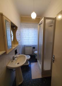 een badkamer met 2 toiletten, een wastafel en een douche bij APPARTAMENTO TRILOCALE CON TERRAZZO ZONA CENTRALE in Grottammare