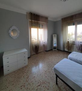 a bedroom with two beds and a dresser and windows at APPARTAMENTO TRILOCALE CON TERRAZZO ZONA CENTRALE in Grottammare