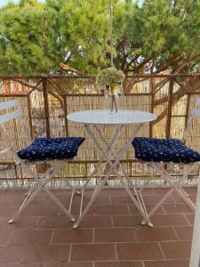 皮昂比諾的住宿－La Casa di Bea，一张带两把蓝色椅子和一张桌子的白色桌子