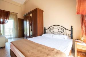 1 dormitorio con 1 cama grande con sábanas blancas en Phaethon Maisonette by RentalsPro - Nea Moudania Halkidiki, en Nea Moudania