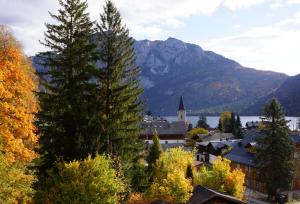 una ciudad con una iglesia y montañas en el fondo en Altes Pfarrhaus, en Altaussee