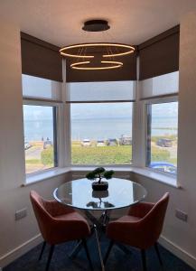 a dining room with a table and two chairs and a window at Eden Retreats Serviced Apartments in Morecambe
