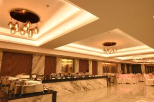 a banquet hall with tables and chairs and chandeliers at HOTEL KLG ALTORIA in Chandīgarh