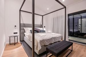 sypialnia z dużym łóżkiem z baldachimem i stołem w obiekcie Luxury Villa Ante with pool w mieście Dobrinj +25 zdjęć