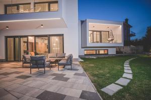 patio z krzesłami i stołem przed domem w obiekcie Luxury Villa Ante with pool w mieście Dobrinj