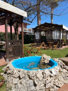 una piccola piscina d'acqua in un cortile con gazebo di Hotel Virginia a Marina di Massa