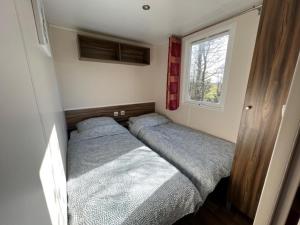 Tempat tidur dalam kamar di chalet kajuit 418 op 5 sterren camping bergumermeer