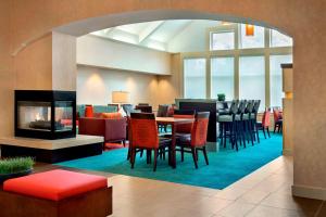 アレンタウンにあるSonesta ES Suites Allentown Bethlehem Airportの暖炉、テーブル、椅子が備わるレストラン