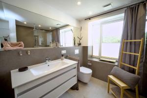 een badkamer met een wastafel, een toilet en een spiegel bij FeWo Prora - Hiddensee 4.2 in Binz