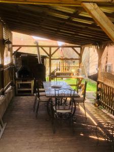 a patio with a table and chairs and a grill at la ferme de manu in Saulxures