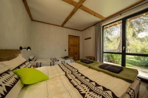 two beds in a room with a window at Adventure Camp Emen in Emen
