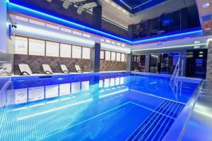 duży basen z niebieskimi światłami w budynku w obiekcie Hotel Rudnik w Grudziądzu