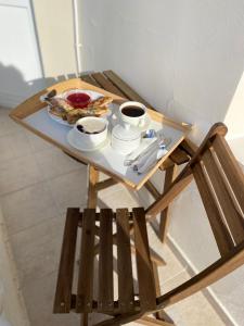 una mesa con una bandeja de comida y dos tazas de café en Lera Guest House, en Loo