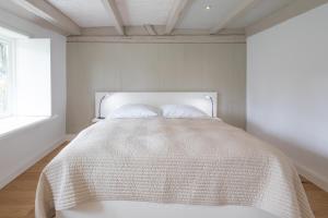 - une chambre avec un lit doté d'un couvre-lit blanc dans l'établissement Ferien unter Reet, à Ostenfeld