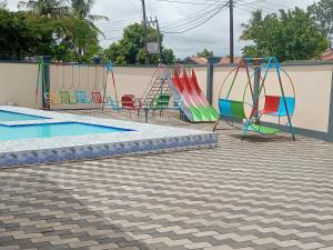 a group of swings and a swimming pool at Chibuba Airport Accommodation in Dar es Salaam