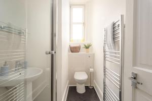 Baño blanco con aseo y lavamanos en The London Road Apartment - 2BR/1BA, en Edimburgo