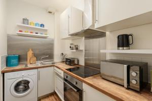 cocina con fregadero y fogones horno superior en The London Road Apartment - 2BR/1BA en Edimburgo