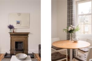 a living room with a table and a fireplace at The London Road Apartment - 2BR/1BA in Edinburgh