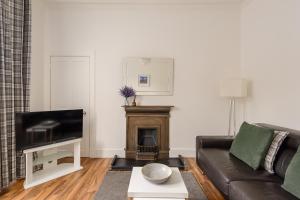 sala de estar con sofá y chimenea en The London Road Apartment - 2BR/1BA, en Edimburgo