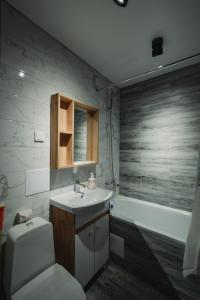 La salle de bains est pourvue de toilettes, d'un lavabo et d'une baignoire. dans l'établissement Двухкомнатная квартира в центре Versace, à Petropavlovsk-Kamtchatski