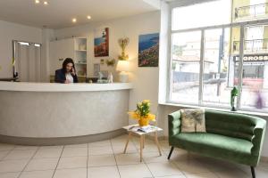 Una mujer hablando por celular en un bar en una tienda en Hotel Ristorante La Marina Mhotelsgroup, en San Bartolomeo al Mare