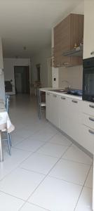 a kitchen with white cabinets and a table and chairs at Casa Marietta in Polignano a Mare