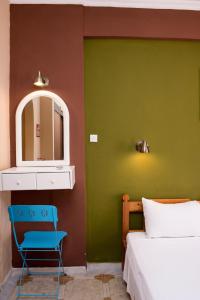 sypialnia z łóżkiem, lustrem i krzesłem w obiekcie Southgate Apartments w mieście Agios Georgios