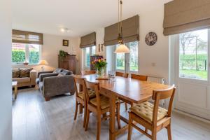 een keuken en een woonkamer met een houten tafel en stoelen bij Fréjus 110 - Kustpark Village Scaldia in Hoofdplaat