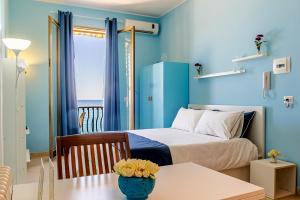 una camera da letto con pareti blu e un letto con tavolo di Pippo House a Giardini Naxos