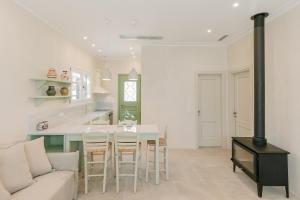 KAVET Palio Cottage في بالايون تسيفليكيون: مطبخ وغرفة معيشة مع طاولة وأريكة