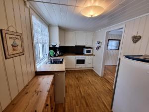 a kitchen with white cabinets and a white refrigerator at Trolltunga Skjeggedal in Skjeggedal